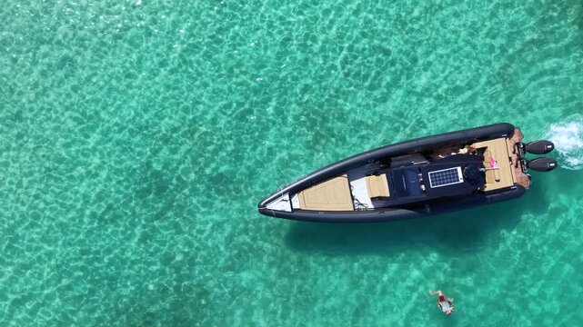 Top-down aerial view of a luxury inflatable motorboat floating over crystal clear turquoise sea, with visible seabed patterns and large copy space creating an idyllic summer travel scene.