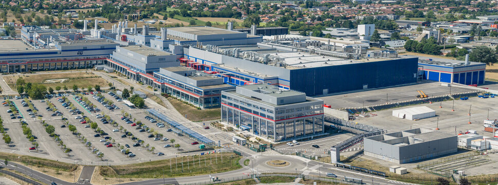 Crolles, Auvergne-Rhone-Alpes, France - 01 August 2026: Aerial view of the STMicroelectronics semiconductor campus, featuring industrial facilities and parking.