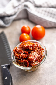 Sun-Dried Tomatoes in Glass Bowl With Olive Oil on Rustic Kitchen Surface