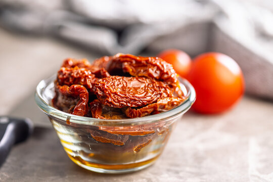 Sun-Dried Tomatoes in Glass Bowl With Olive Oil on Rustic Kitchen Surface