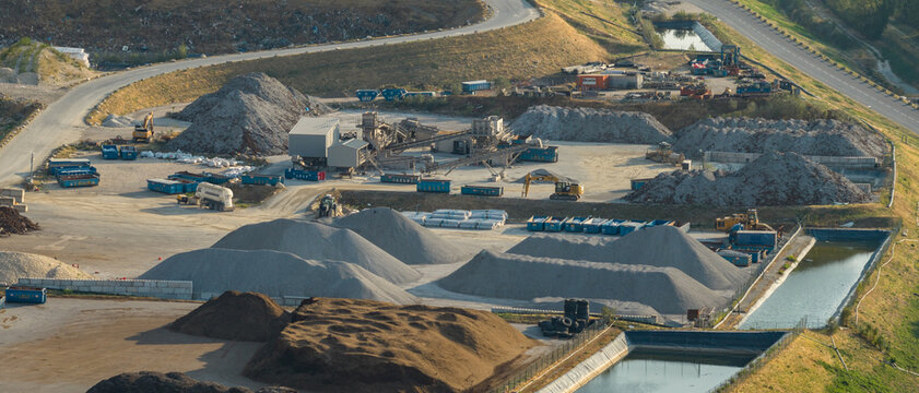 Saint-Quentin-sur-Isere, France - 02 August 2026: Aerial view of a construction and demolition waste recycling facility with conveyor belts, aggregate processing, and stockpiles.