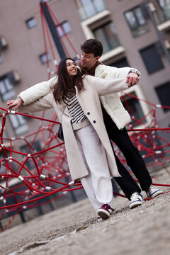 Happy couple enjoying playful outdoor moments together in a city setting