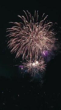 Vertical view of grand fireworks finale show exploding in the night sky