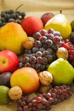 Fresh autumn fruits and walnuts composition with grapes apples and pears