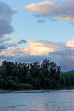 Peaceful River and Forest Landscape at Sunset With Dramatic Clouds in Chilliwack, BC Canada