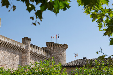 Tiedra castle battlements and tower flying flags against blue sky © Azulblue