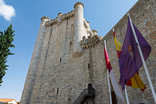 Tiedra castle displaying medieval architecture and historic flags