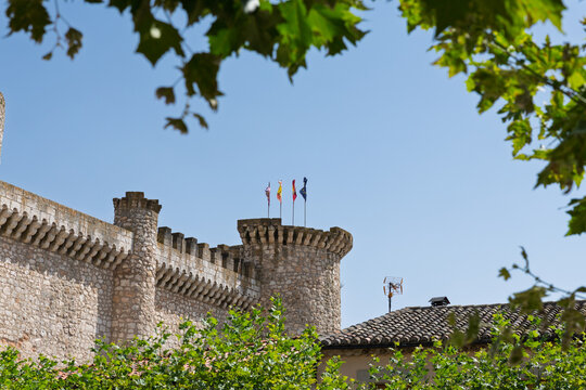 Tiedra castle battlements and tower flying flags against blue sky