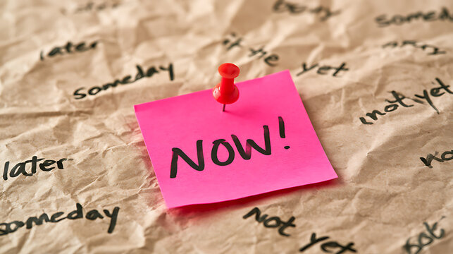 Vibrant pink sticky note with 'NOW!' message pinned to crumpled paper, surrounded by deferring words
