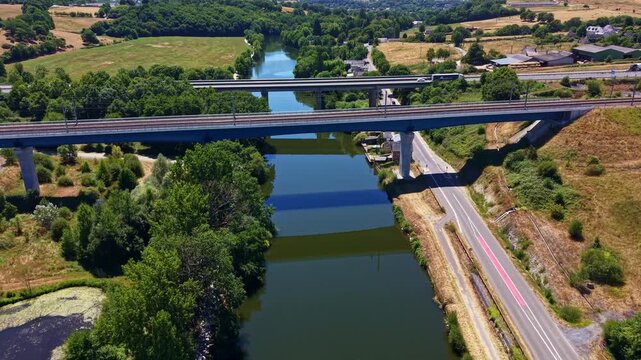 Approaching drone shot toward twin L'Armoricaine highway bridges crossing Mayenne River environment through countryside landscape, Change, Mayenne, France