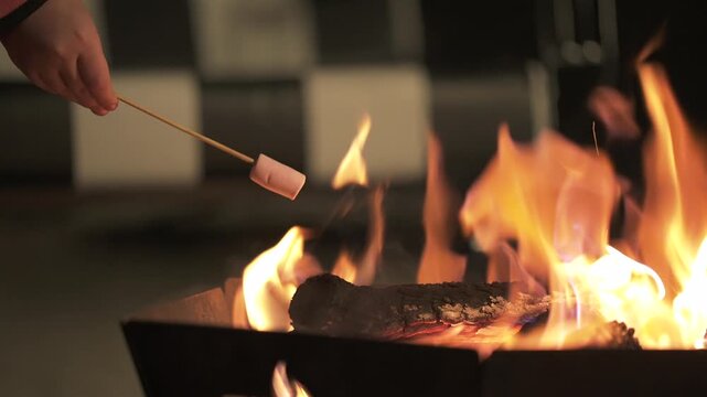 Marshmallows roast on skewers above a glowing outdoor fire pit in Mendoza