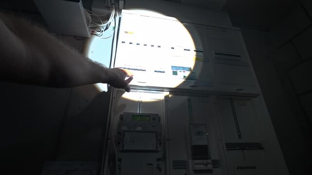 POV walking to the electrical fuse box with a flashlight during a power outage. Ideal for blackout, emergency, home safety, and electricity concepts.
