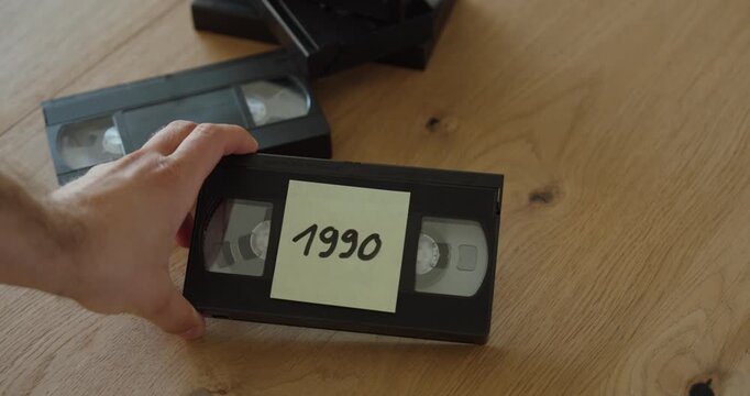 Close-up of an old VHS cassette labeled "1990". Ideal for 1990s nostalgia, vintage home videos, family memories, analog media, archives, and video digitization concepts.