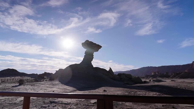Sunlit mushroom rock rises above the desert landscape at El Hongo