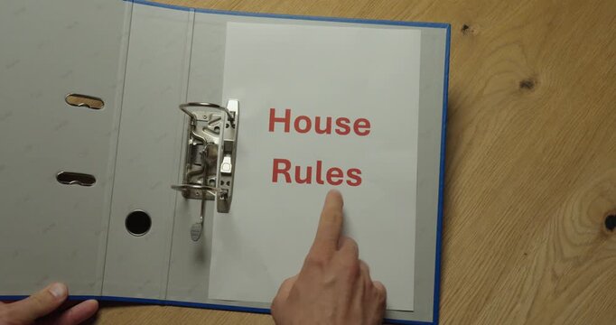 Person looking up house rules in a binder. Ideal for regulations, property management, tenant policies and building guidelines.