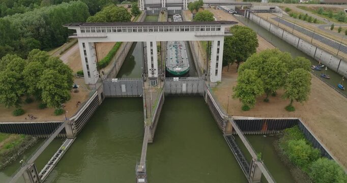 Drone pulls away from an inland tanker vessel waiting in a lock chamber for the sluice gate to open, allowing it to continue its journey along the Dutch canal and inland waterway.