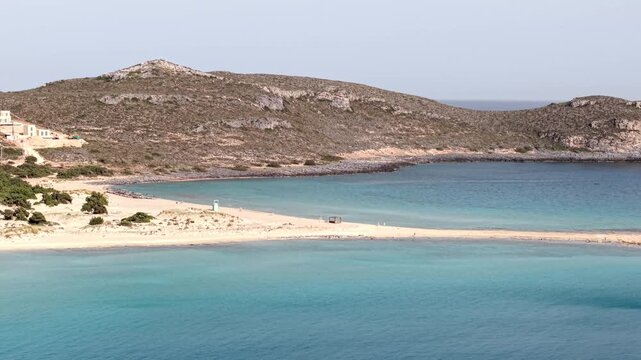 Simos beach double bay with rugged limestone mountain in background into Aegean Sea, Elafonisos island, Aerial view