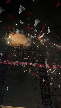 Pyrotechnic fireworks exploding from traditional castillo during Mexican celebration