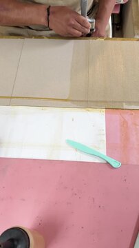 Artisan spreading glue on cardboard during handcrafting process