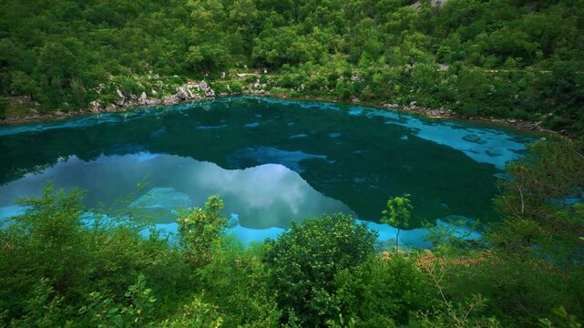 Vibrant blue water of Lago Cornino mountain lake near the Tagliamento river. Scenic natural landscape