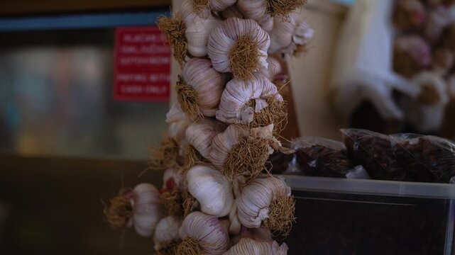 Close-up of braided garlic bulbs displayed for sale among fresh goods at the Zadar farmers market.