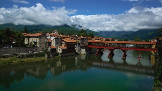 Iconic historic wooden bridge Ponte degli Alpini spanning the clear river in Bassano del Grappa.
