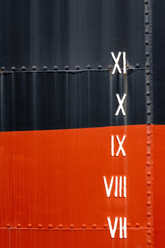 Draft marks with Roman numerals on a ship hull, color block metallic texture with rivets