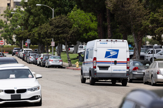 Fullerton, California / USA - August 13, 2026: A USPS (United States Postal Service) mail truck makes a delivery on a city street.