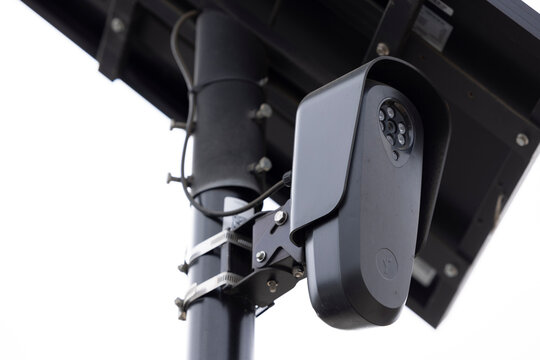 Fullerton, California, USA - August 14, 2026: An AI Flock camera surveils a city street for car license plates on a dark cloudy day.