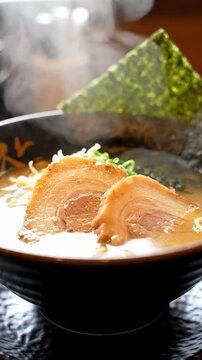 Steaming hot bowl of Japanese ramen with tender chashu pork and nori