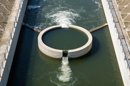 Circular holding basin between a turbulent inflow and a calm outlet