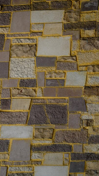 Vertical stone wall texture pattern with stacked geometric tiles rustic natural slate rock surface background for architectural facade design interior feature wall exterior building cladding