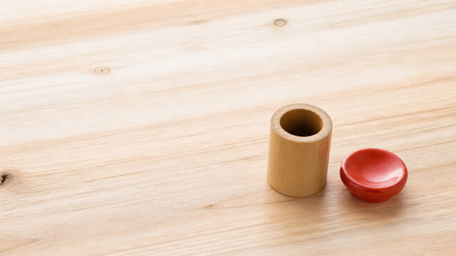 杉の板に並べた茶道具の蓋置 竹と朱の陶器と余白のある背景