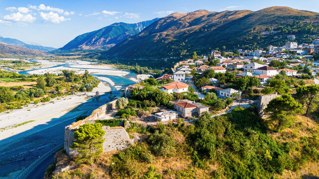 Aerial view of the rugged mountain landscape, Tepelene Castle ruins, and the wide riverbed of the Vjosa in Albania