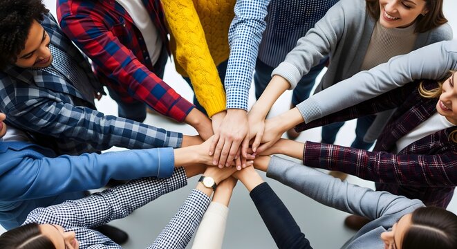 Diverse business team stacking hands together for unity and cooperation