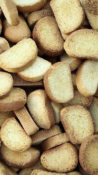 Pile of golden crispy toasted bread rusks and slices with porous texture. Ideal for breakfast, snack or bakery themes.