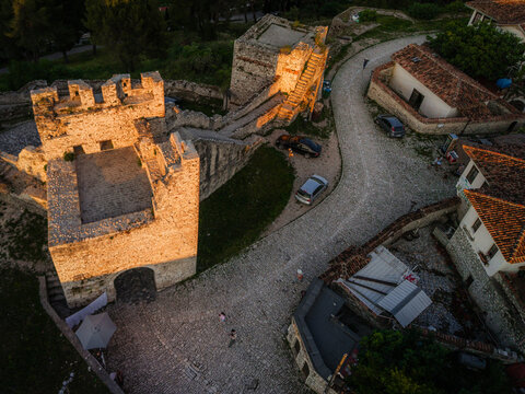 Aerial view of the historic stone walls and cobblestone paths of Berat Castle at sunset with traditional houses in Berat, Berat County, Albania.