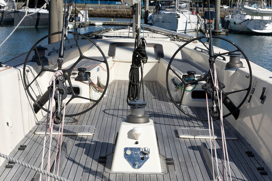 Sailing boats at a marina on a sunny day. Dual Steering wheels for ocean racing