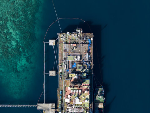Aerial view of a Floating Storage and Offloading Ship FSO moored in clear turquoise waters with a support vessel alongside, Buleleng Regency, Bali, Indonesia.