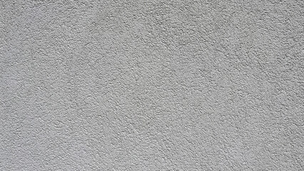 Close‑up of a light gray stucco wall with a fine uniform roughcast finish, creating a clean minimalist architectural texture background with subtle granular detail and neutral tones. © Martins