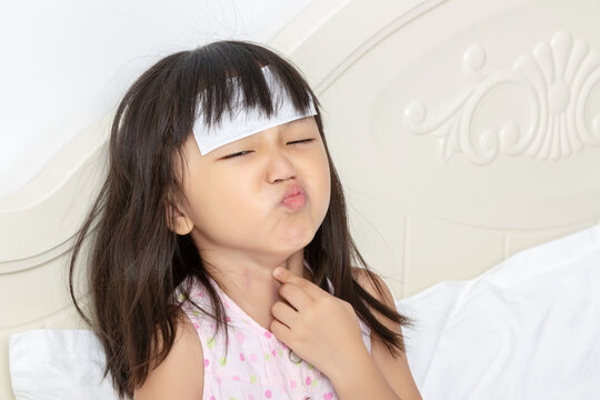 Asian Little Girl with Sore Throat and Fever Feeling Pain