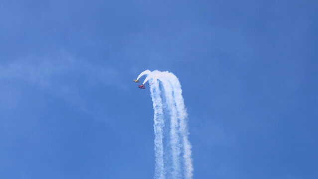 Aerobatic Planes Performing Stunts with Smoke Trails in Blue Sky