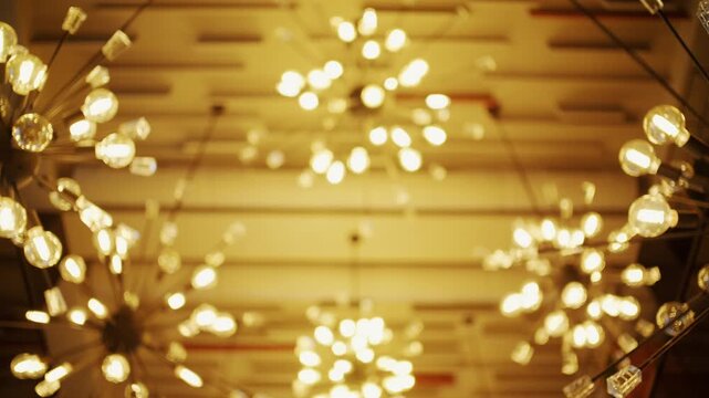 Low angle view of modern spherical starburst chandeliers hanging from decorative ceiling in interior space.