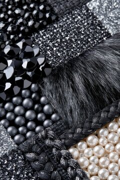 Dark fashion moodboard showcasing an array of textures such as black beads, sequins, faux fur, and braided materials in a detailed arrangement