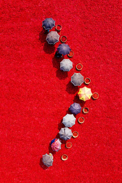 Aerial view of workers with umbrellas drying red chilies in baskets on a vast field in Bogura, Rajshahi Division, Bangladesh.