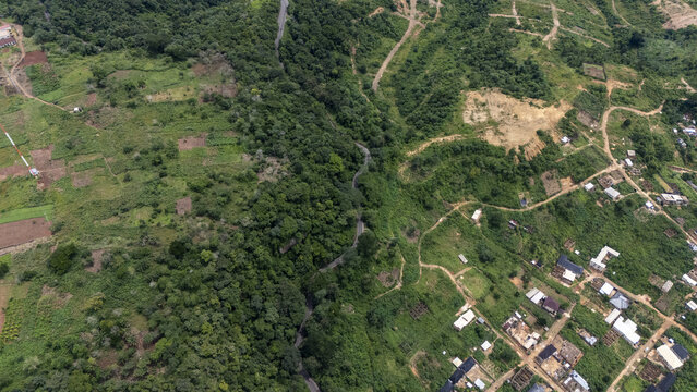Aerial view of the Enugu-Onitsha Road winding through lush green vegetation and rural settlements in Enugu, Enugu, Nigeria.
