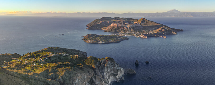 Aerial view of the volcanic Aeolian Islands, including Vulcano and Lipari, surrounded by the Tyrrhenian Sea under golden hour light in Lipari, Sicily, Italy.