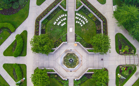 Aerial view of the Beal Botanical Garden at Michigan State University featuring a central fountain, manicured lawns, flower beds, and white chairs in East Lansing, Michigan, United States.