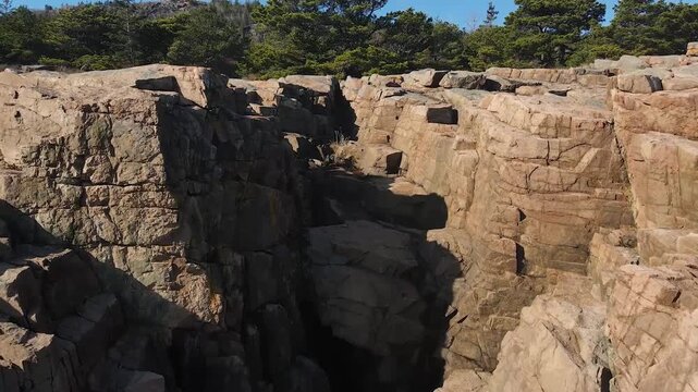 Iconic pink granite cliffs rise above the clear blue Atlantic waters in Acadia National Park