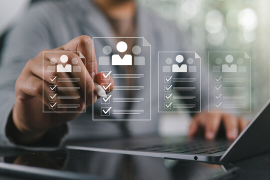 Businessman using laptop with virtual interface for online recruitment and human resources management, selecting candidate profiles. Concept of HR technology, digital hiring, and modern workforce